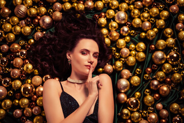 Top view photo of gorgeous stunning lady touch fingers lips ask keep silence feel mysterious near x mas golden toys
