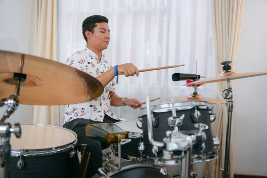 Man playing drums in his bedroom
