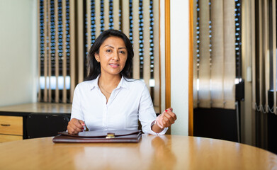 Positive young adult businesswoman working at meeting room in office