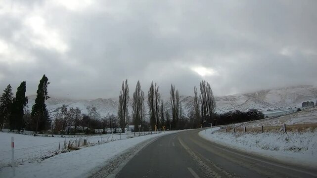 Scenic winter drive along Crown Range Road between Queenstown and Wanaka, Cardrona Oatgo New Zealand, Snow-covered mountains and winding roads serene alpine landscape