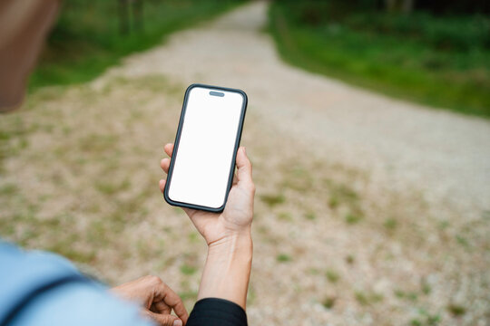 A woman uses a mobile phone with a white screen