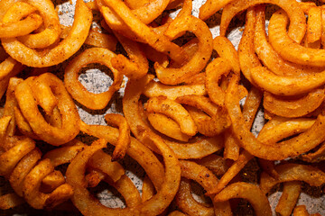 Close-up of curly fries on a metal tray 