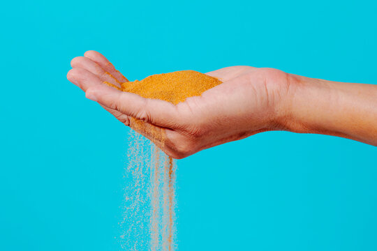 sand slipping through the fingers of a man