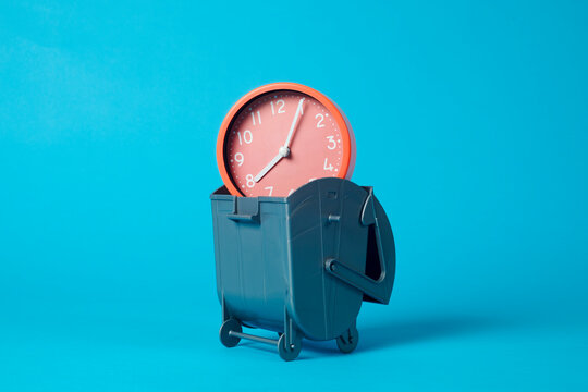 pink clock in a garbage container
