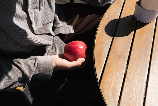 Man holding an apple in cafe