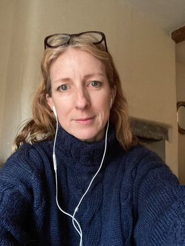 A woman with headphones and glasses ready for a work call in winter