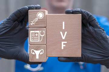 Doctor holding wooden blocks with icons and sees acronym: IVF. IVF In Vitro Fertilization Concept. Infertility treatment. Medical procedure for pregnancy.