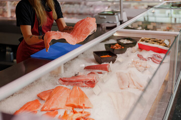 A vibrant and diverse assortment of fresh fish and seafood displayed on ice at a bustling local...