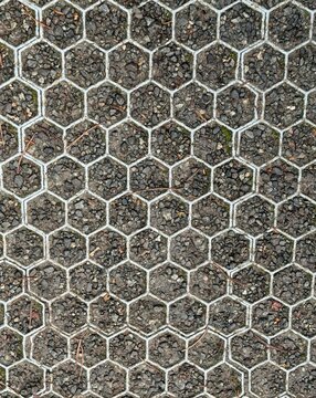 Plastic and gravel hardstanding over grass with hexagonal design - image