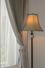 a lamp stand against a gray window curtain interior in a hotel