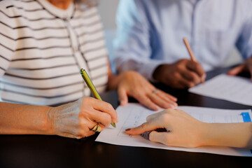 Senior couple signing contract with financial advisor at home
