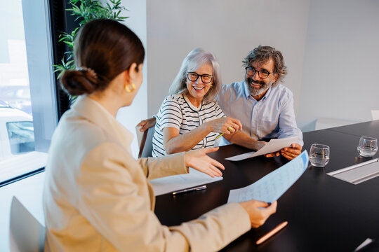Financial advisor explaining documents to happy senior couple