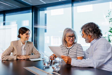 Senior couple reviewing documents with financial advisor