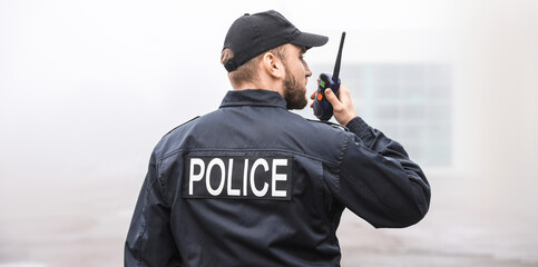 Male police officer patrolling city street