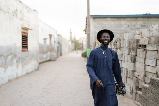 Smiling senegalese man walking in a street wearing traditional clothes
