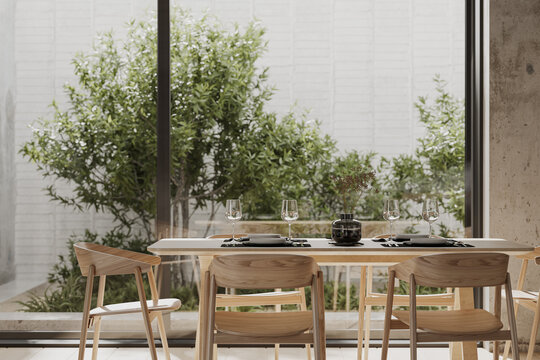 Elegant dining table set in modern concrete interior with garden view