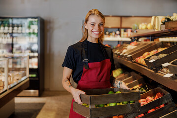In a vibrant and lively market, a friendly grocery store worker enthusiastically showcases a crate...