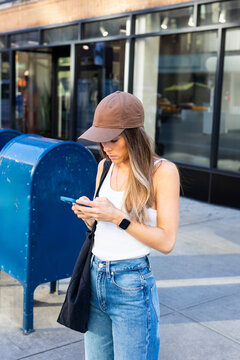 Vacationer texting on a phone while standing on a street in New York