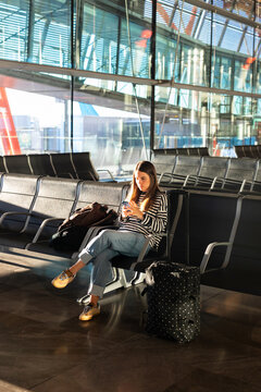 Visitor waits for a flight sitting on a bench at the New York airport