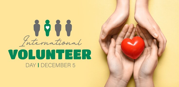 Hands with red heart on yellow background. Banner for International Volunteer Day