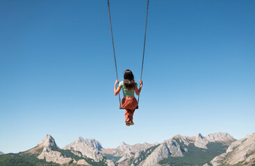 Swinging woman enjoying peaceful mountain view