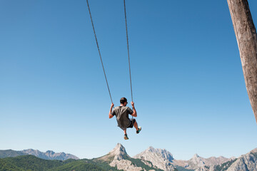 Man enjoying daydream mountain swing