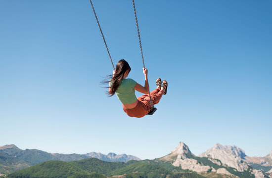 Daydream swinging at scenic mountain landscape