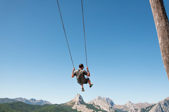 Man enjoying daydream mountain swing