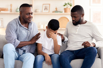 Family Support. Black father and grandfather comforting upset little boy at home, soothing preteen kid, showing empathy and love