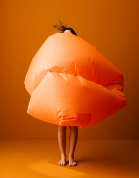 Creative Portrait of Person Wrapped in Giant Orange Fabric