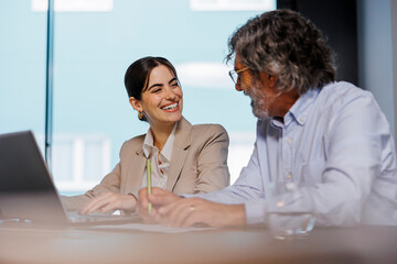 Business people working on laptop in meeting room