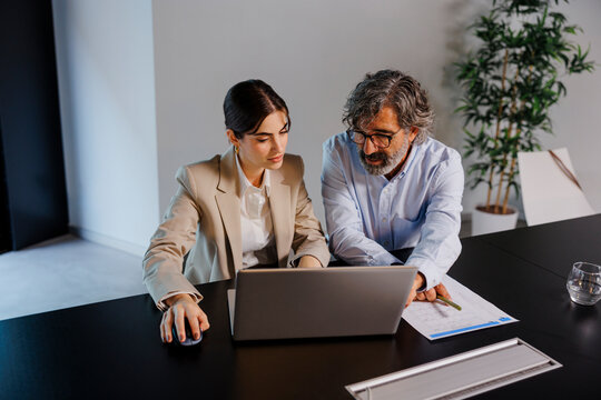 Business people working together using laptop in office