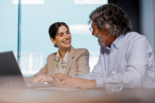Business people working on laptop in meeting room