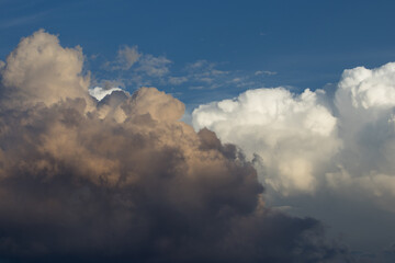 Dramatic sky with heavy rain clouds overlaying white clouds at dusk 2