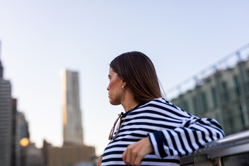 Female vacationer takes in the New York City skyline on a calm day