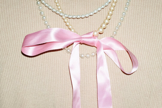 Turtleneck and shiny pearl necklaces & silk ribbon bow and flashlight