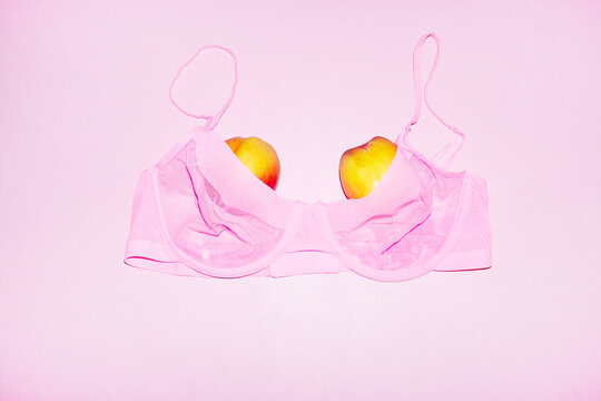 Pink bra and juicy peach fruits as boobs with hard direct flashlight