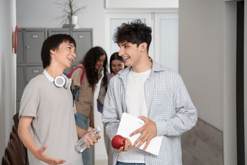 Male teenage students talking at school hall