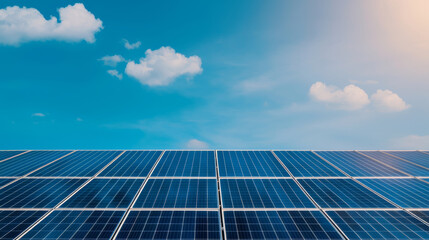 Solar panels reflecting sunlight under clear blue sky with clouds, showcasing renewable energy technology and sustainability
