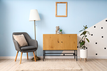 Interior of modern room with comfortable armchair, commode and houseplants near color wall
