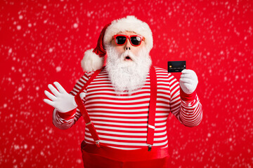 Portrait of his he nice handsome amazed stunned Santa using holding in hand bank card December...