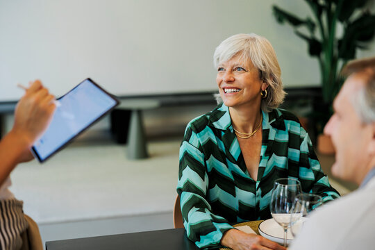 Woman ordering food using digital menu in restaurant