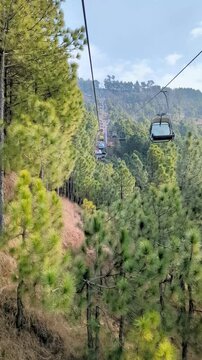 Chairlifts passing through pine trees forest in Patriata, Murree, Pakistan. Chairlifts cable car in northern areas of Pakistan.