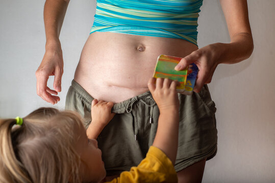 Mother with a cesarean section scar with a baby