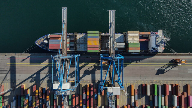 Aerial View of Crane Loading Shipping Containers at Port