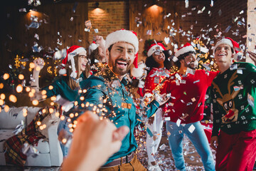 Photo of cheerful young people friends group nice guy pull hand follow cheerful smile cozy christmas party decor spacious apartment indoors