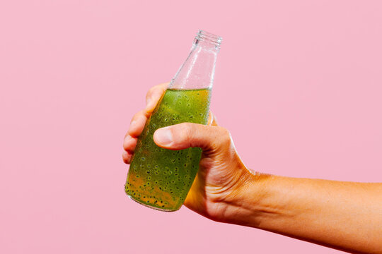 man with a bottle with a kiwi drink with basil seeds in his hand