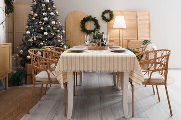 Interior of dining room with table, Christmas tree and wreaths