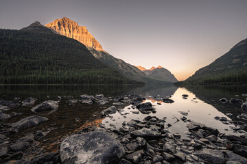 Sun Sets Over The Rocky Shore Of Upper Kintla Lake In Glacier