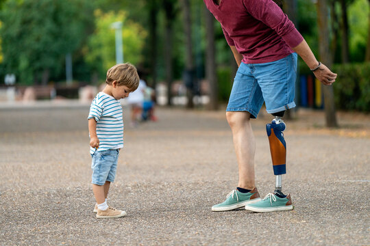 Child and parent with prosthetic leg enjoying park walk